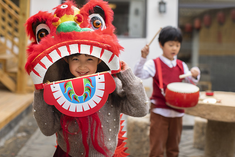 快乐的兄妹俩在院子里舞狮子图片下载